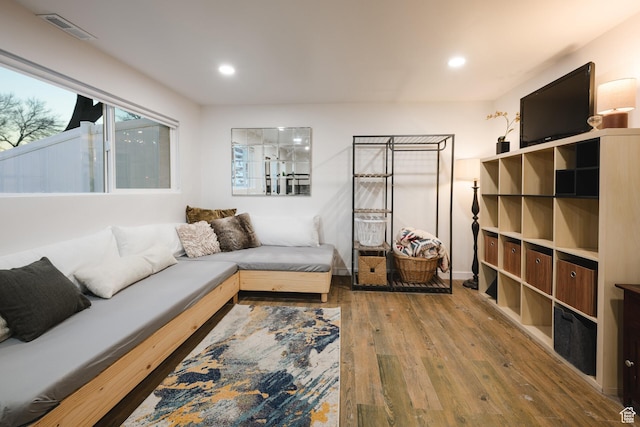 living room with recessed lighting, visible vents, and hardwood / wood-style flooring