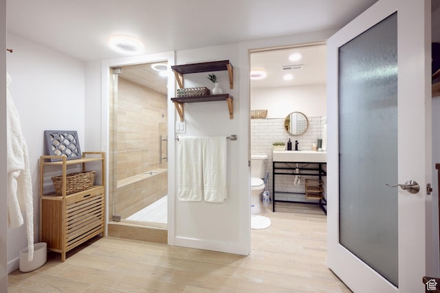 full bath featuring a shower stall, vanity, visible vents, and toilet