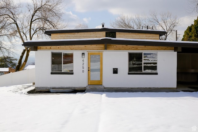 bungalow with stucco siding and fence