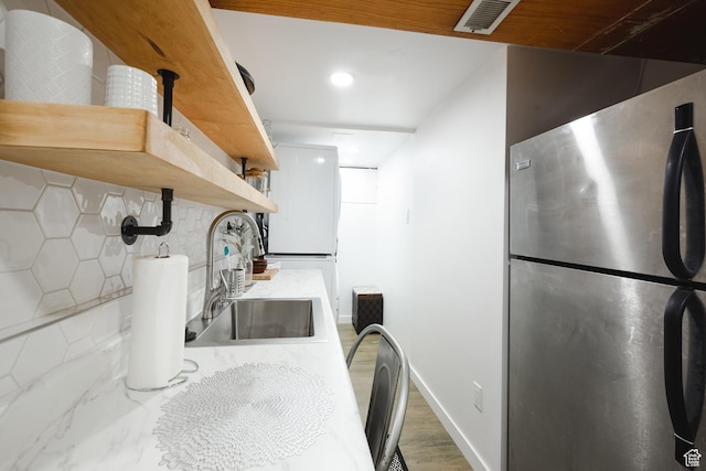 kitchen featuring visible vents, open shelves, a sink, light countertops, and freestanding refrigerator