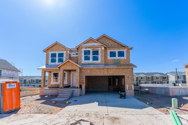 view of front of house with fence, a carport, and driveway