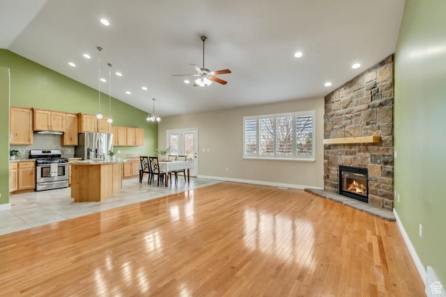 1184 W Michaelsen, West Jordan, UT 84088 - living room with light wood-style floors, high vaulted ceiling, ceiling fan, a fireplace, and baseboards