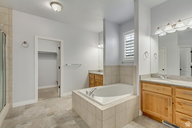1184 W Michaelsen, West Jordan, UT 84088 - full bath featuring visible vents, a spacious closet, a shower stall, two vanities, and a garden tub