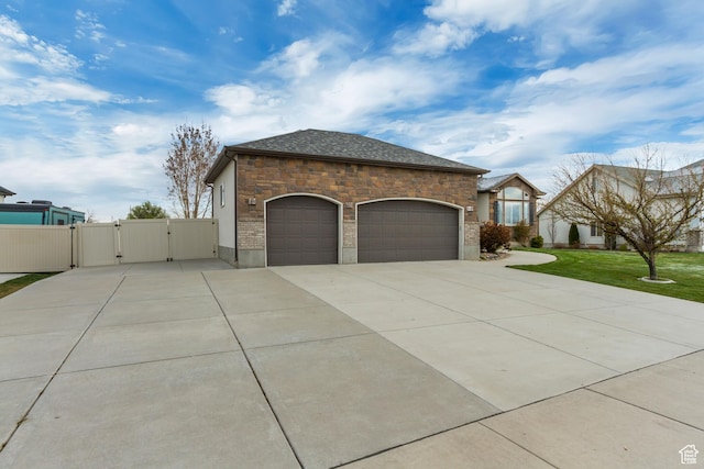 1184 W Michaelsen, West Jordan, UT 84088 - view of side of property featuring stone siding, a lawn, a garage, concrete driveway, and a gate