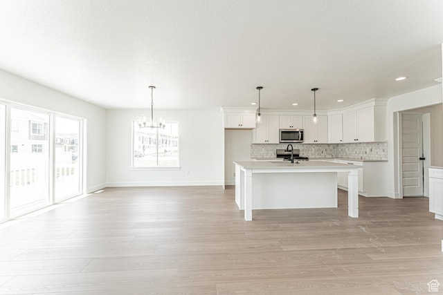 3759 W 950 N Unit 376, Lehi, UT 84043 - kitchen with stainless steel microwave, a chandelier, recessed lighting, backsplash, and light countertops