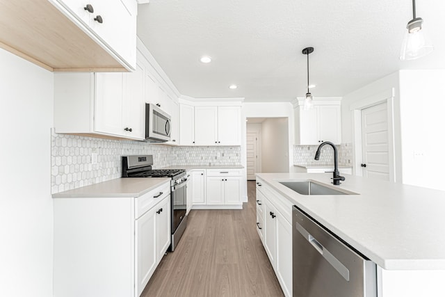 3759 W 950 N Unit 376, Lehi, UT 84043 - kitchen with stainless steel appliances, light wood-style floors, light countertops, tasteful backsplash, and a center island with sink