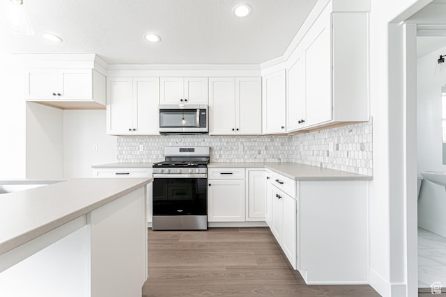 3759 W 950 N Unit 376, Lehi, UT 84043 - kitchen featuring appliances with stainless steel finishes, light countertops, white cabinets, recessed lighting, and backsplash