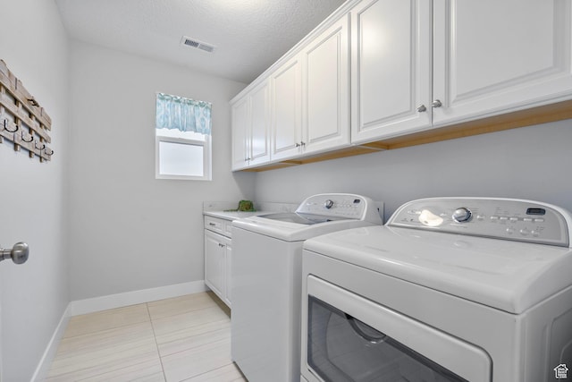 15097 S Cantle Dr, Bluffdale, UT 84065 - washroom featuring washing machine and clothes dryer, cabinet space, baseboards, a textured ceiling, and light tile patterned floors