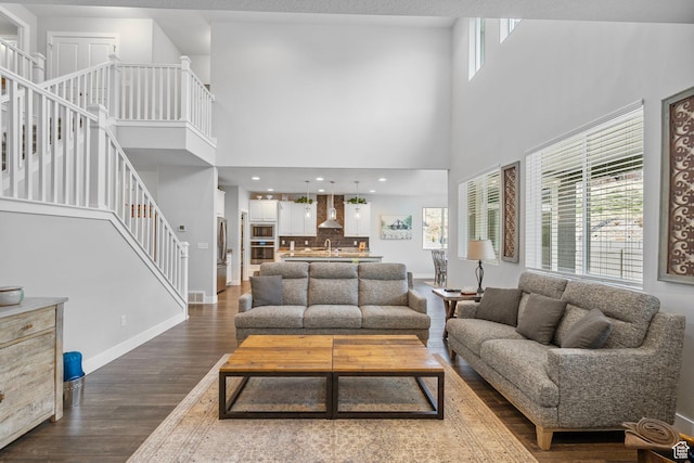 15097 S Cantle Dr, Bluffdale, UT 84065 - living area with dark wood-style flooring, stairs, baseboards, and a high ceiling