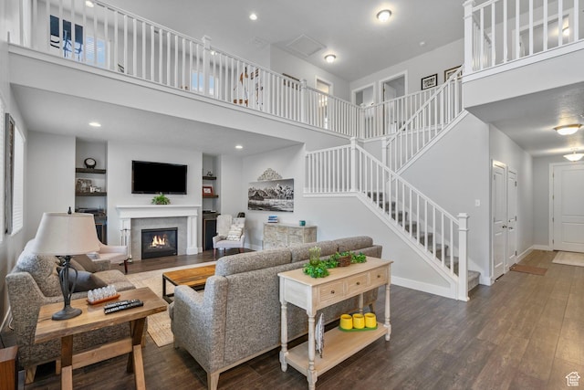 15097 S Cantle Dr, Bluffdale, UT 84065 - living area with a towering ceiling, wood finished floors, stairway, a glass covered fireplace, and baseboards