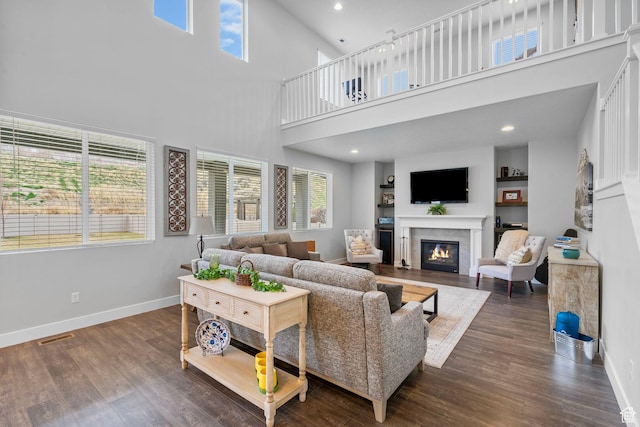15097 S Cantle Dr, Bluffdale, UT 84065 - living room featuring a glass covered fireplace, a high ceiling, baseboards, wood finished floors, and recessed lighting