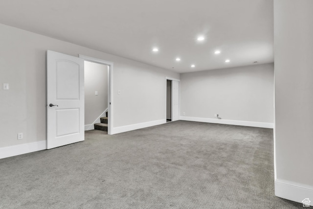 unfurnished room featuring baseboards, carpet, stairway, and recessed lighting