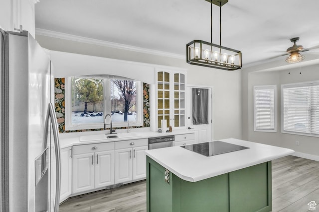 kitchen featuring green cabinets, crown molding, stainless steel appliances, white cabinetry, and a sink