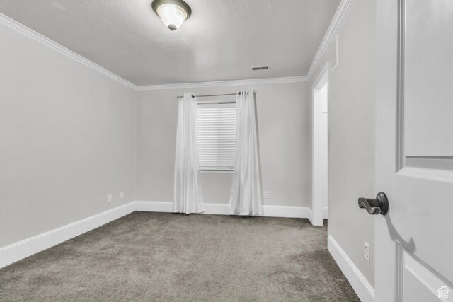 empty room featuring ornamental molding, carpet, baseboards, and visible vents