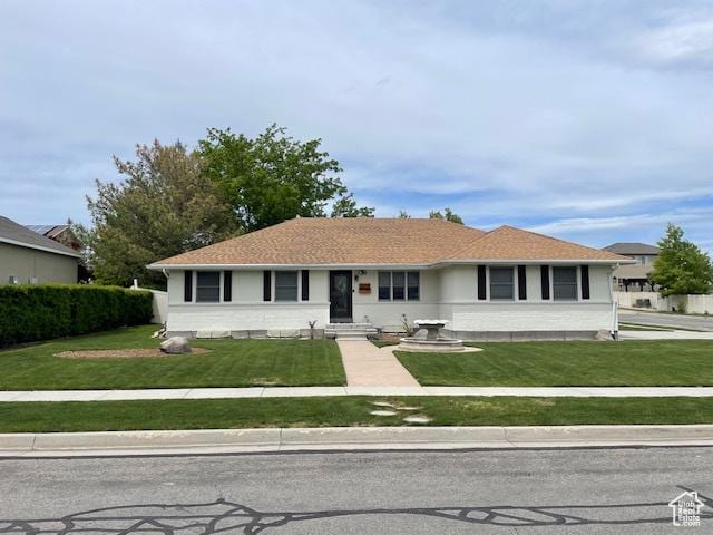 ranch-style home with a front yard and entry steps