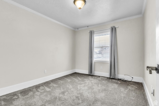 carpeted empty room featuring baseboards and crown molding