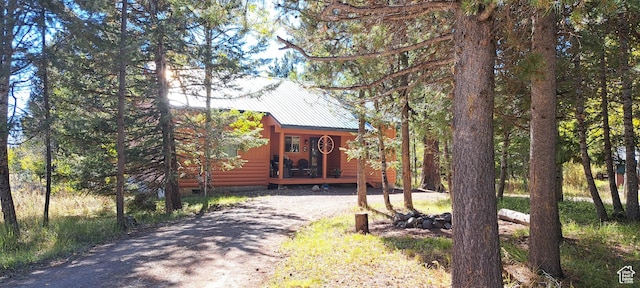 3526 Browning Rd, Island Park, ID 83429 - view of front of property featuring faux log siding, crawl space, driveway, and metal roof