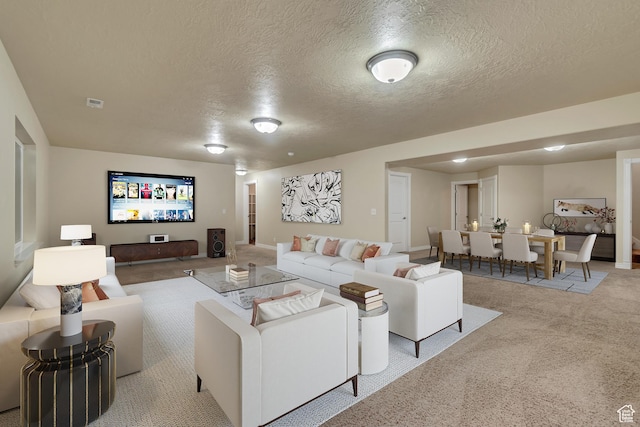 living area featuring carpet flooring, a textured ceiling, and visible vents