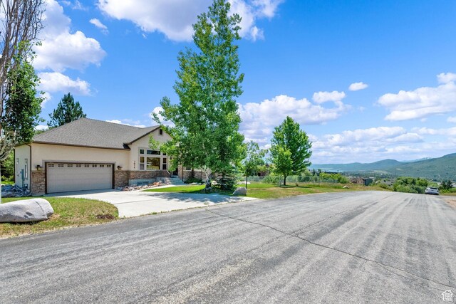 3674 N Willow Brooke Ln, Eden, UT 84310 - ranch-style house featuring driveway, stone siding, stucco siding, a garage, and a mountain view