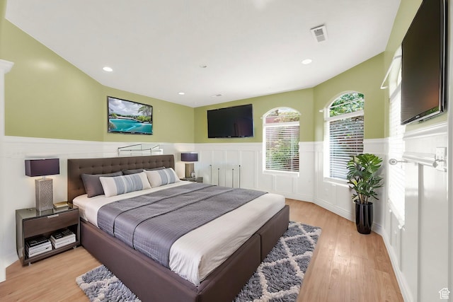 bedroom featuring recessed lighting, visible vents, light wood-style floors, and wainscoting
