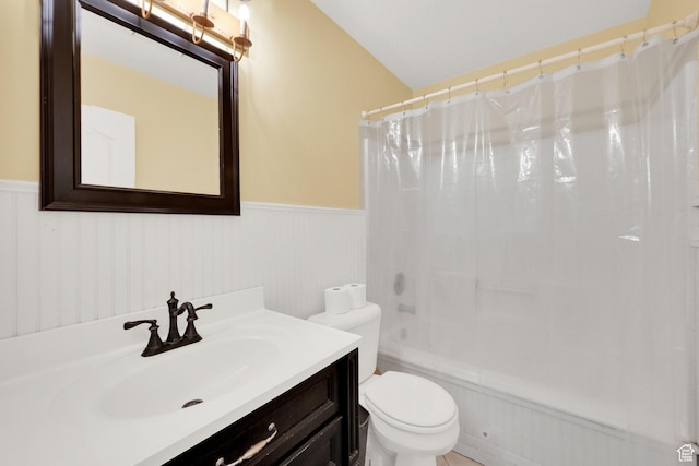 bathroom featuring wainscoting, toilet, shower / tub combo with curtain, and vanity