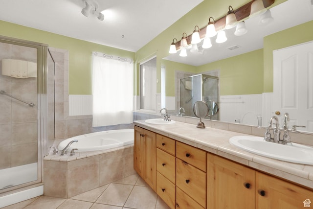 full bath with tile patterned floors, a sink, a garden tub, and visible vents