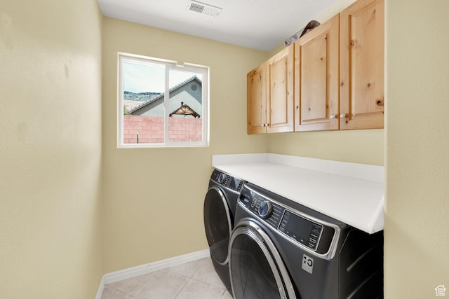 laundry room featuring separate washer and dryer, light tile patterned floors, baseboards, visible vents, and cabinet space