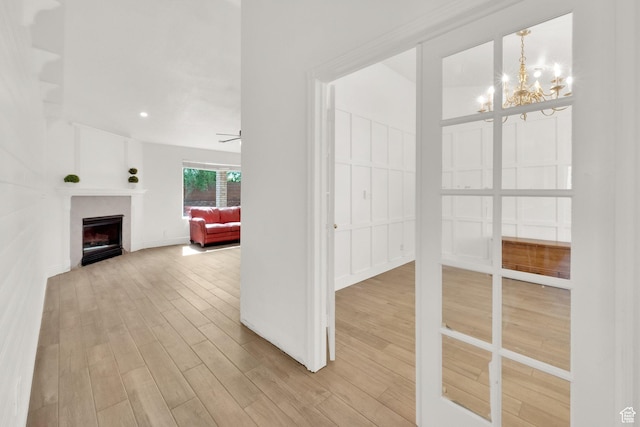 hallway featuring a chandelier and wood finished floors