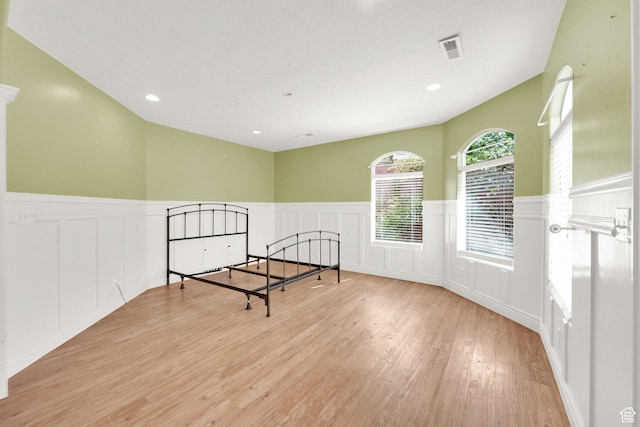 interior space featuring a wainscoted wall, visible vents, wood finished floors, and recessed lighting