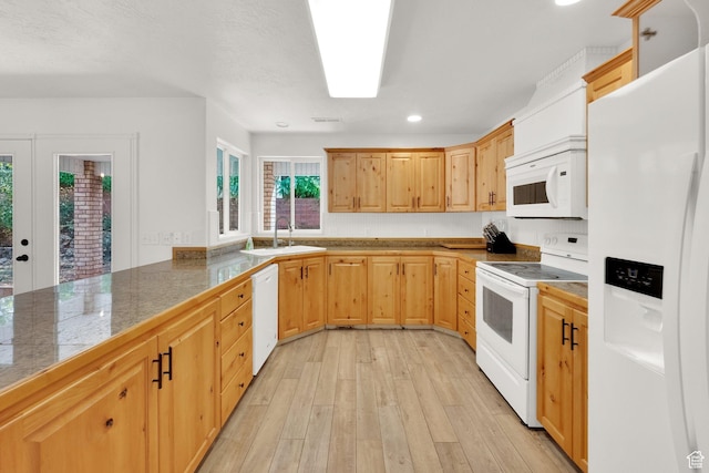 kitchen featuring a sink, tile counters, light brown cabinetry, light wood-type flooring, and white appliances