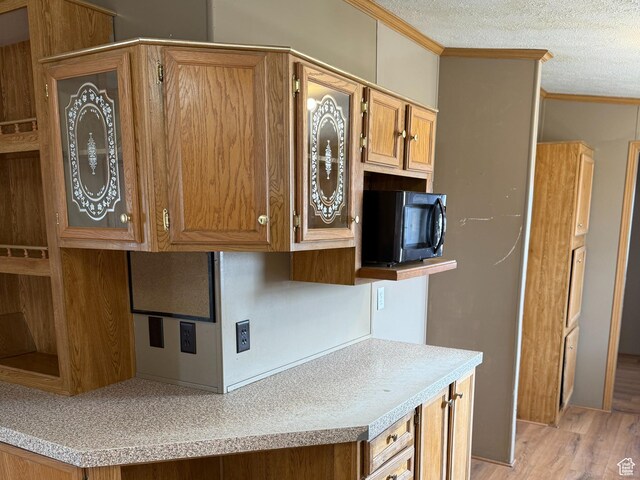 2445 N 260 W, Elmo, UT 84521 - kitchen featuring brown cabinets, light countertops, ornamental molding, and a textured ceiling