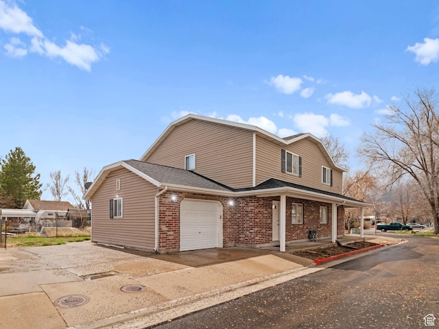 476 W 365 S, Logan, UT 84321 - view of front of house with a gambrel roof, concrete driveway, roof with shingles, brick siding, and a garage