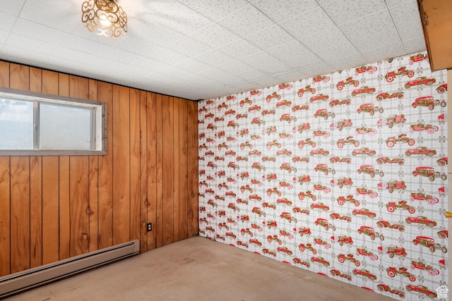 377 E Shore Rd, Saint Charles, ID 83272 - spare room featuring wood walls, a baseboard heating unit, and concrete flooring