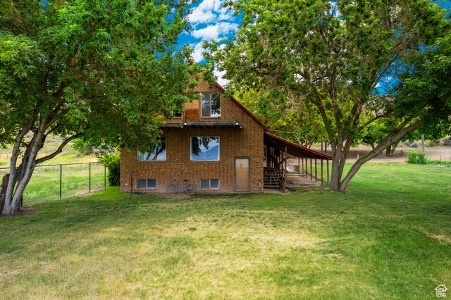 377 E Shore Rd, Saint Charles, ID 83272 - back of house featuring brick siding, fence, and a lawn