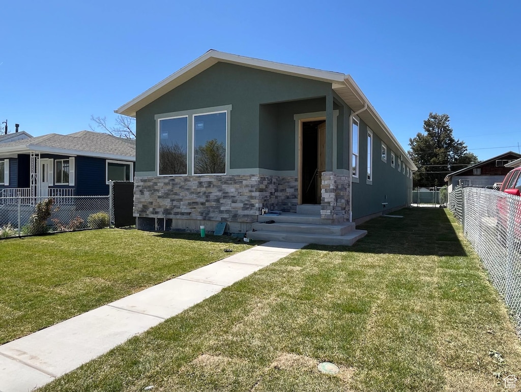 565 N 1200 W, Salt Lake City, UT 84116 - view of front of home with a front lawn, fence, stone siding, and stucco siding