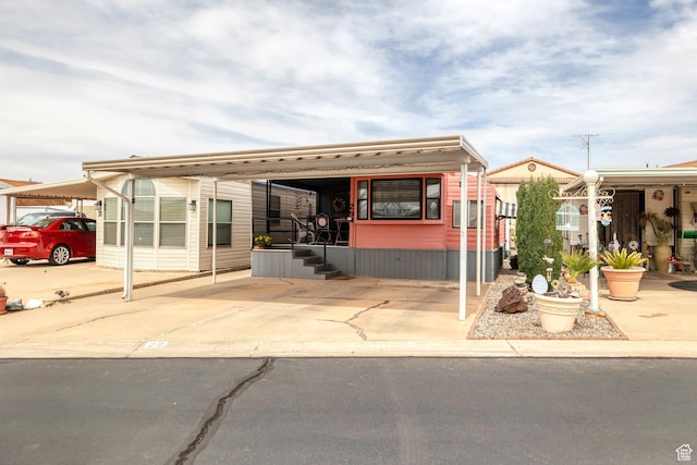 1225 N Dixie Downs Rd Unit 29, St George, UT 84770 - view of building exterior featuring concrete driveway and a carport