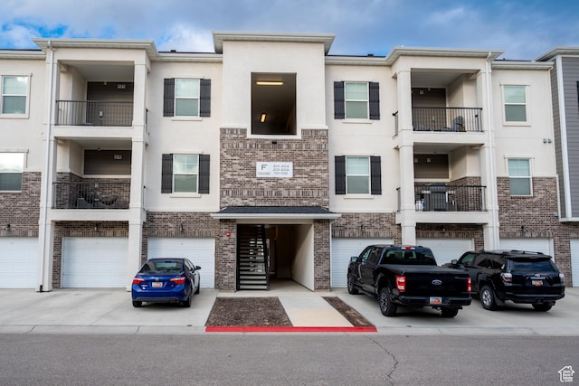 13091 S Newbridge Ln Unit F202, Herriman, UT 84096 - view of building exterior featuring driveway and a garage