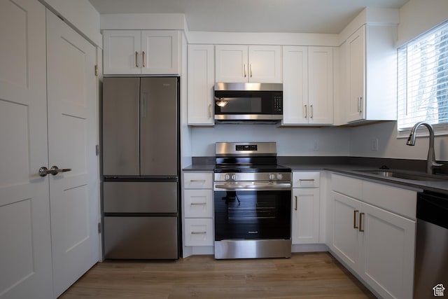3510 S 300 E Unit E, South Salt Lake, UT 84115 - kitchen with stainless steel appliances, a sink, dark countertops, and white cabinetry