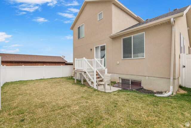 3414 S Melanie Cv W Unit 13, Magna, UT 84044 - rear view of house featuring stucco siding, a fenced backyard, and a yard