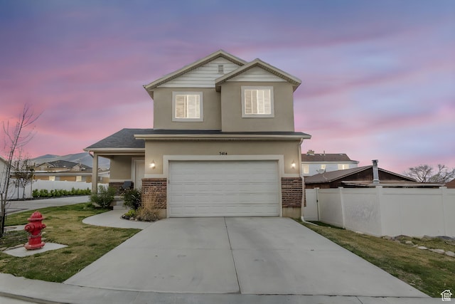 view of front of property with fence, a garage, stucco siding, brick siding, and driveway