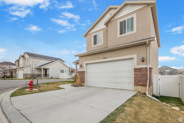 3414 S Melanie Cv W Unit 13, Magna, UT 84044 - view of front of home featuring fence, a garage, concrete driveway, brick siding, and stucco siding