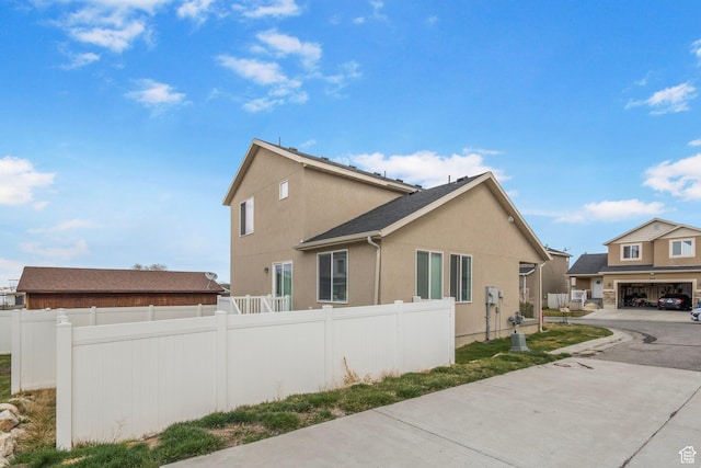 3414 S Melanie Cv W Unit 13, Magna, UT 84044 - view of side of property with stucco siding, a garage, fence, and concrete driveway