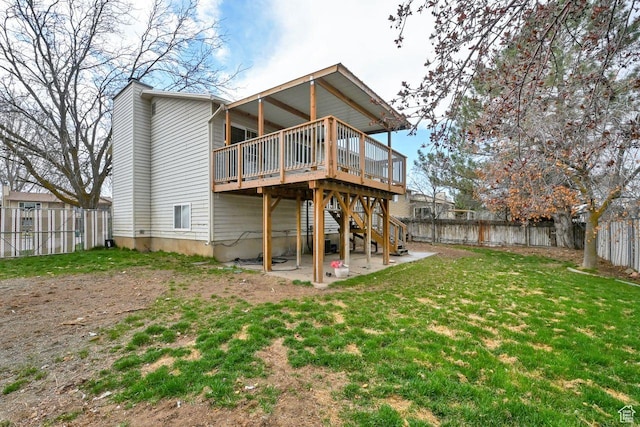 back of house with stairway, a deck, a fenced backyard, a patio, and a yard