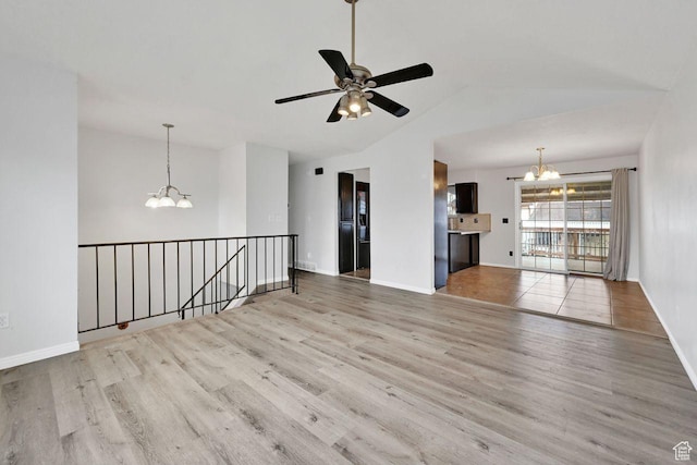 unfurnished living room with baseboards, wood finished floors, vaulted ceiling, and ceiling fan with notable chandelier