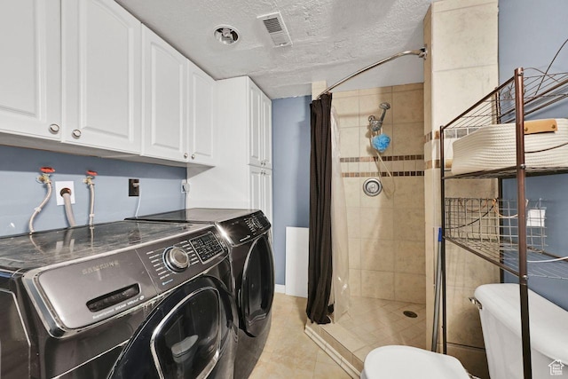 washroom featuring washing machine and clothes dryer, a textured ceiling, laundry area, and visible vents