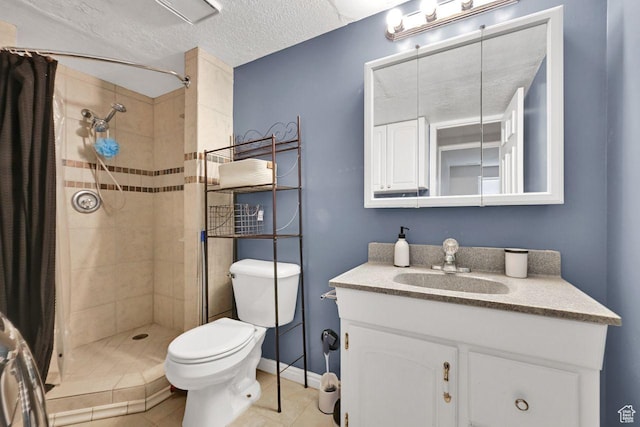 full bathroom featuring toilet, vanity, a tile shower, and a textured ceiling