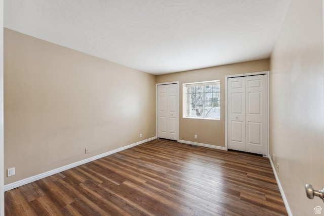 499 N 200 W Unit 8, Bountiful, UT 84010 - unfurnished bedroom featuring dark wood-type flooring, multiple closets, and baseboards
