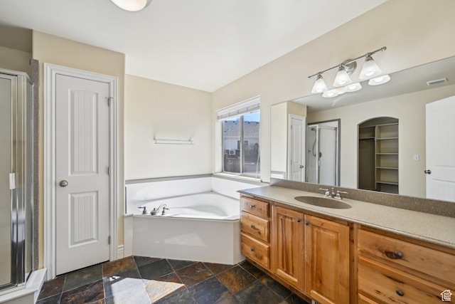664 E Oak Wood Dr N Unit 50, Heber City, UT 84032 - full bath featuring visible vents, stone finish floor, vanity, a stall shower, and a garden tub