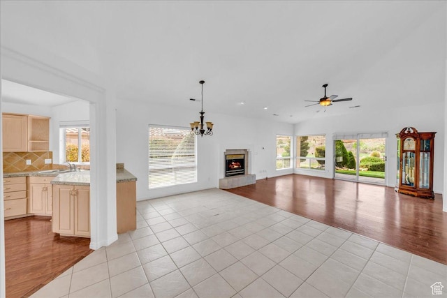 356 N Cactus Ln Unit 7, Washington, UT 84780 - unfurnished living room featuring ceiling fan with notable chandelier, a lit fireplace, a sink, and light tile patterned floors