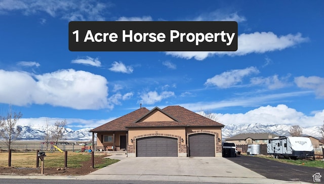 546 S Quirk St, Grantsville, UT 84029 - french provincial home with a playground, an attached garage, concrete driveway, stucco siding, and a mountain view